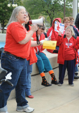 Individuals speaking out about their rights in public forum holding signs.